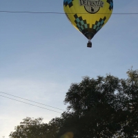 Hot air balloon taking off from across the road