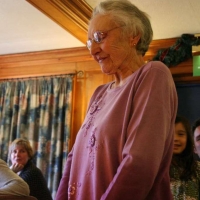 Winnie stands to cut her cake